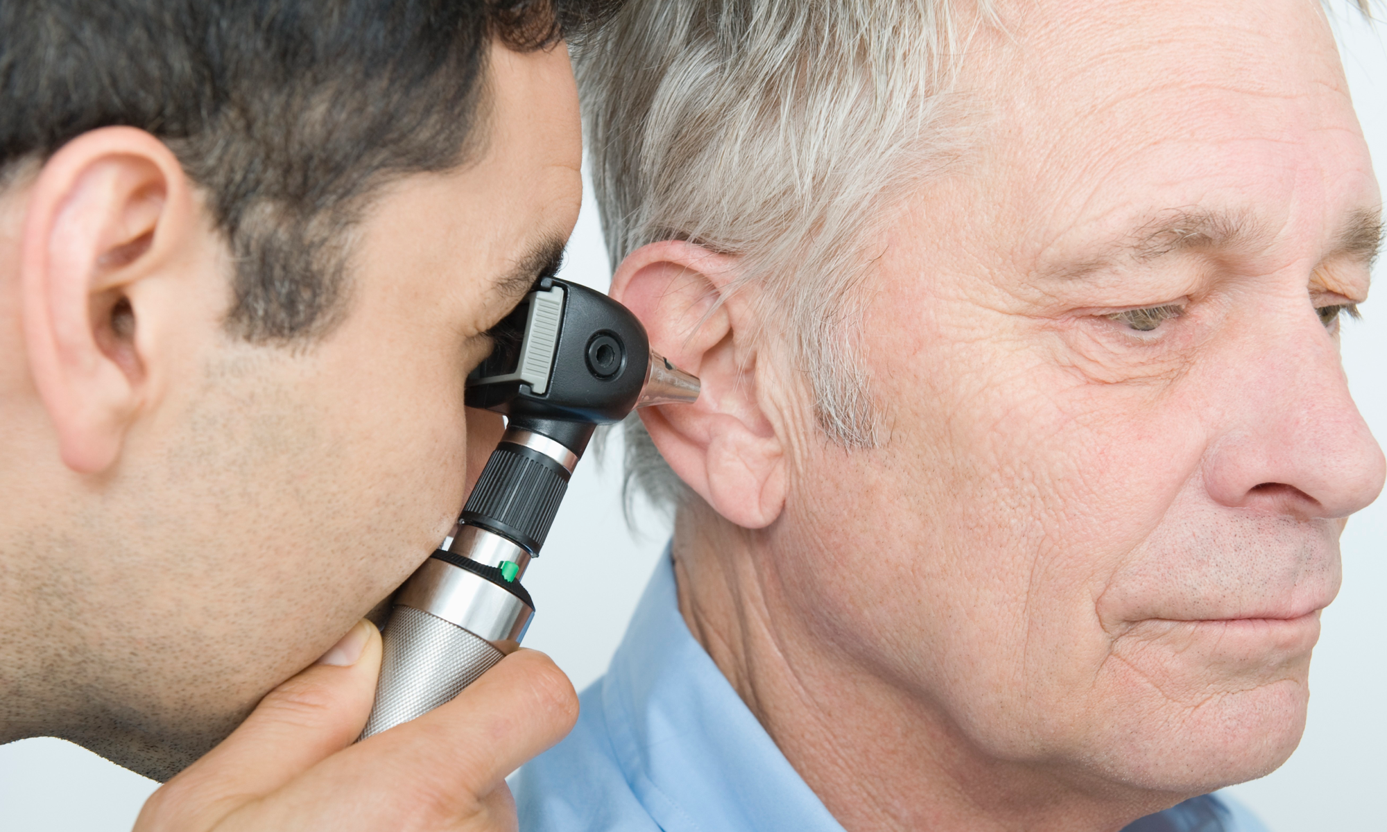 An image of one man peering into another man's ear.