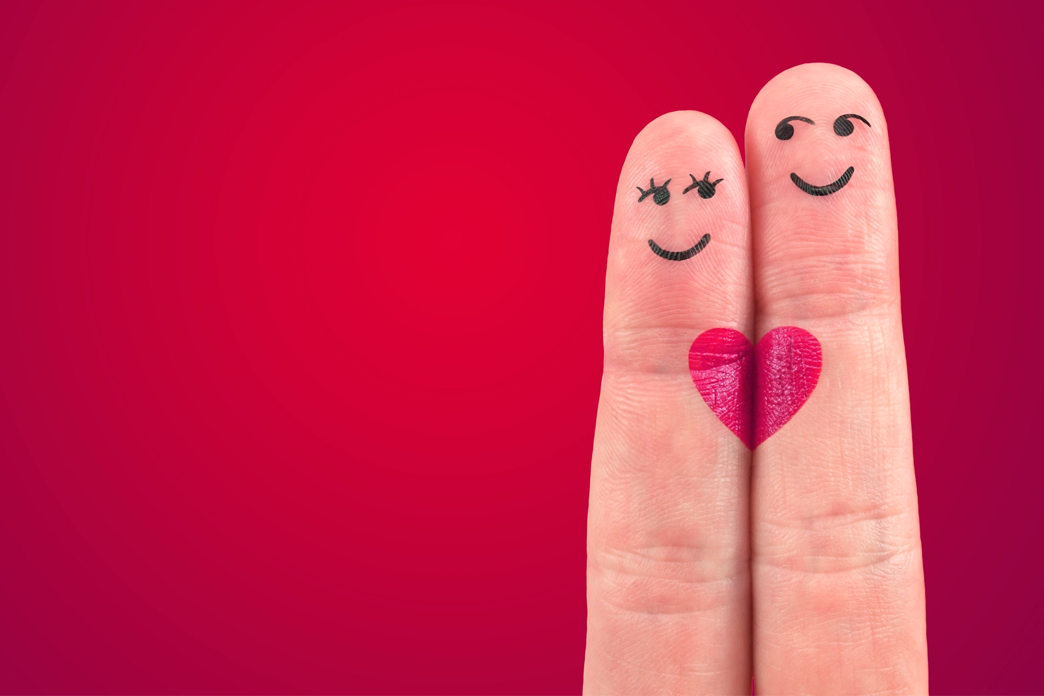 Two fingers together, with little people drawn on them, and a heart joining them.