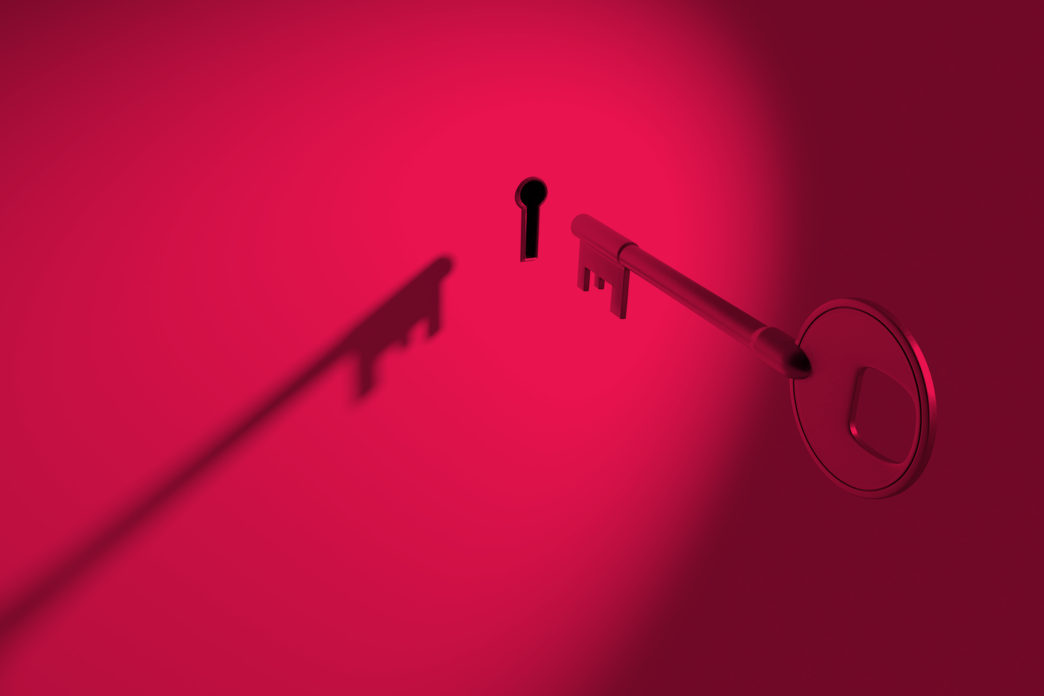 A dramatic photo of a key nearing a keyhole.